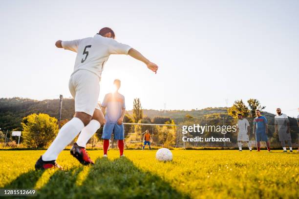 jugador de fútbol recibiendo tiro libre - liga de fútbol fotografías e imágenes de stock