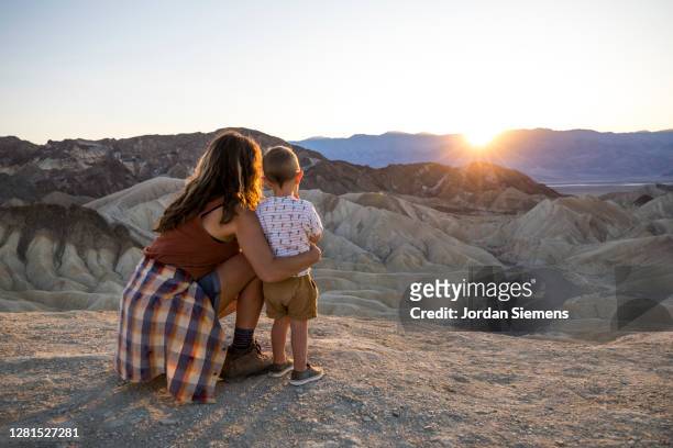 a mother and her son taking in the sunset at a viewpoint in death valley - family rear view stock pictures, royalty-free photos & images