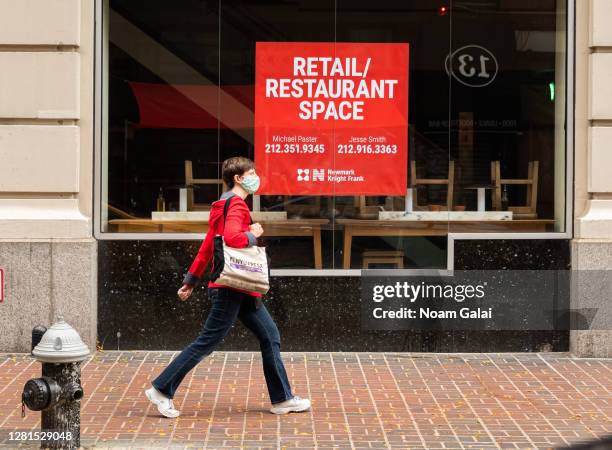 Person walks by a restaurant that went out of business in the East Village as the city continues the re-opening efforts following restrictions...