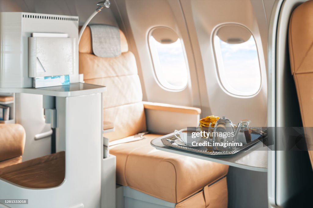 First Class Flugzeugsitz mit Tablett mit Essen
