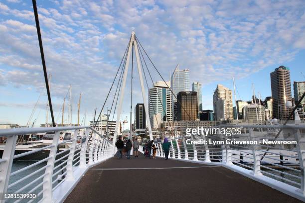 Pedestrians cross the bridge at Lighter Basin, Viaduct Harbour, in Auckland on October 17 the night of the 2020 general election, shortly after the...