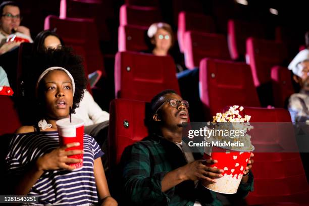 pareja afroamericana viendo una película aterradora en el cine - when we were young and afraid opening night fotografías e imágenes de stock