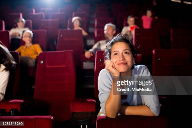 ritratto di una giovane donna che si gode un film romantico al cinema - festival del cinema foto e immagini stock