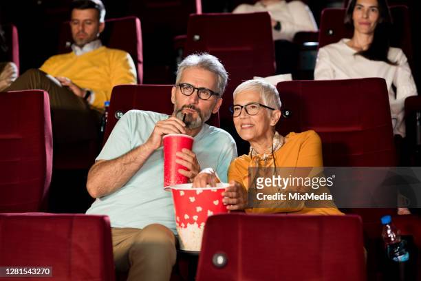 coppia senior che guarda un film al cinema - prima cinematografica foto e immagini stock