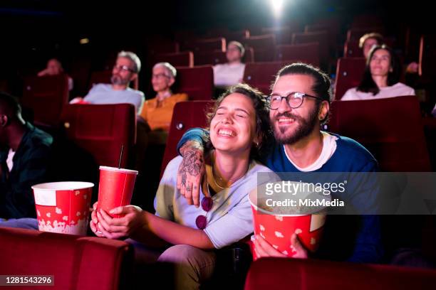 joven pareja en una cita viendo una película en el cine - lovers 2020 film fotografías e imágenes de stock