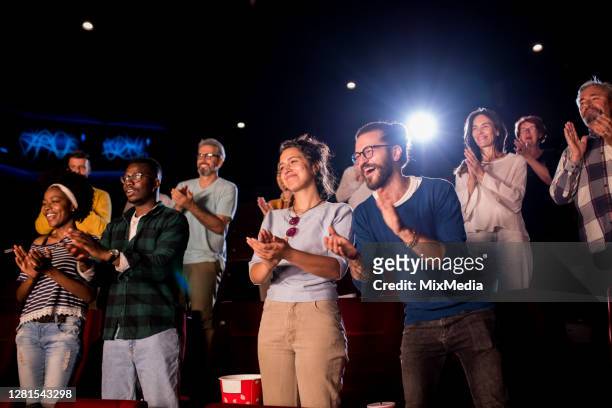 satisfied audience applauding at the end of a movie at the cinema - film festival stock pictures, royalty-free photos & images