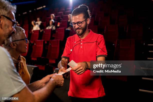young controller at the cinema checking the tickets to spectators - film festival stock pictures, royalty-free photos & images