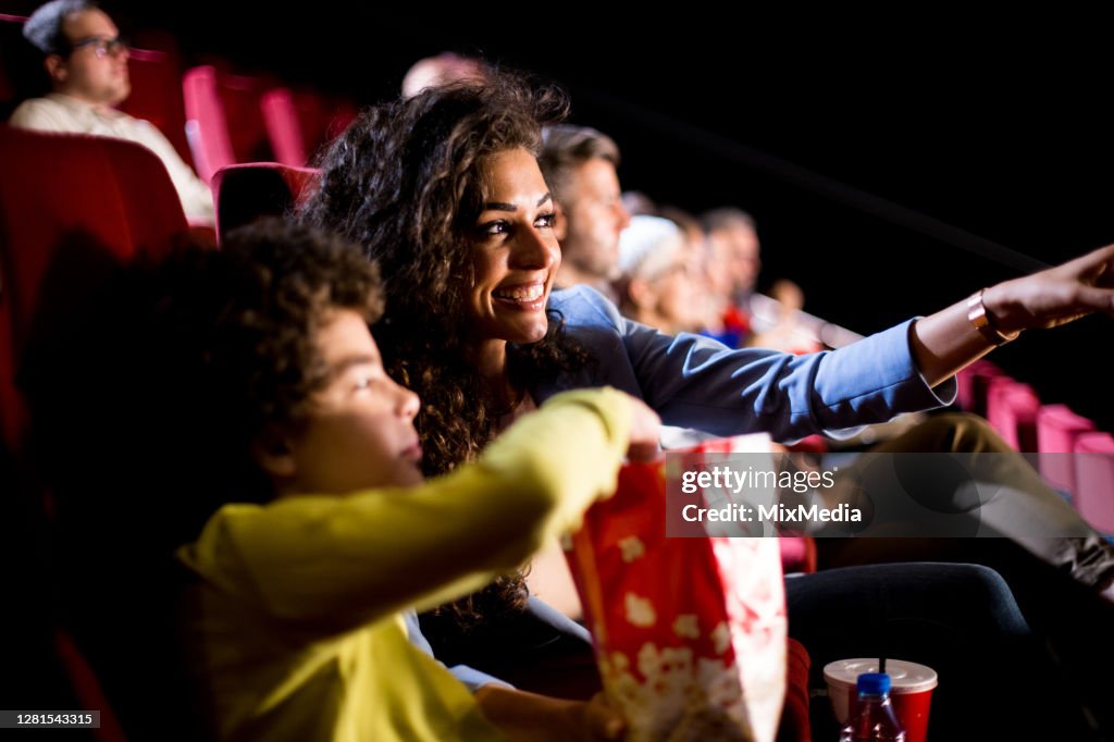 Mujer feliz disfrutando con su hijo en el cine