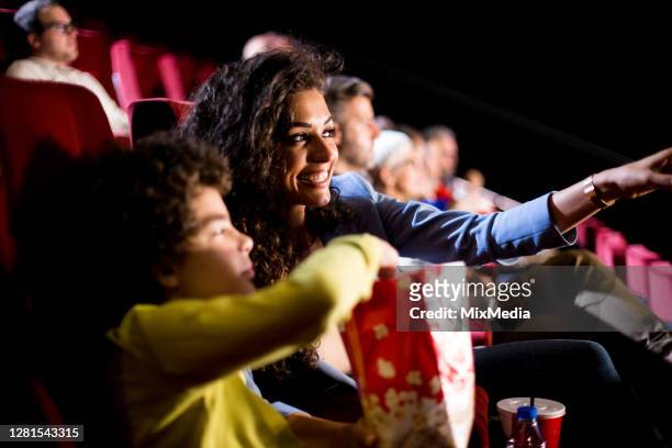 donna felice che si diverte con suo figlio al cinema - prima cinematografica foto e immagini stock