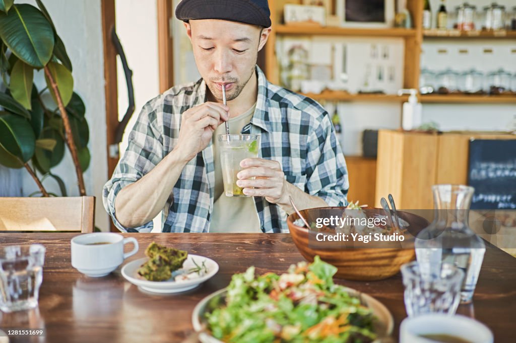Man drinks a kiwi fruit drink at a vegan restaurant