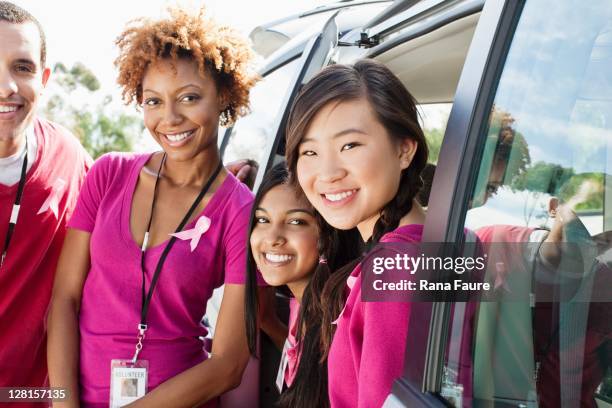 team in purple t-shirts - magenta car stock pictures, royalty-free photos & images