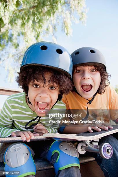 portrait of two boys (10-12) with skateboards - kniebeschermer stockfoto's en -beelden