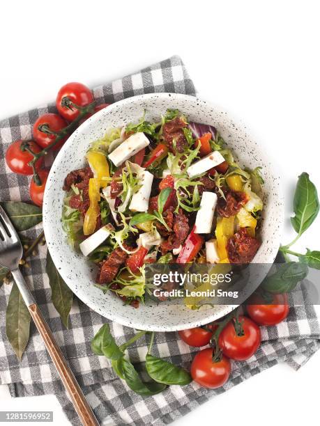 food photography of vegetable salad with sun dried tomatoes and soft cheese on a white background isolated top view - salladsskål bildbanksfoton och bilder