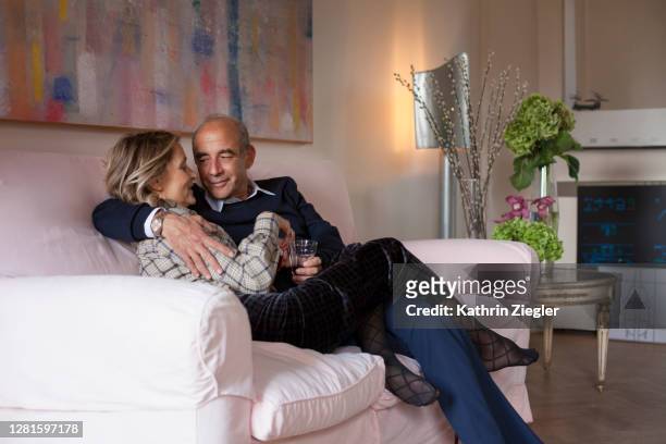 affectionate mature couple relaxing on the sofa - house for an art lover stock pictures, royalty-free photos & images