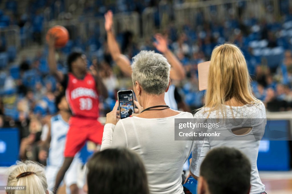 Spectators photographing during the match
