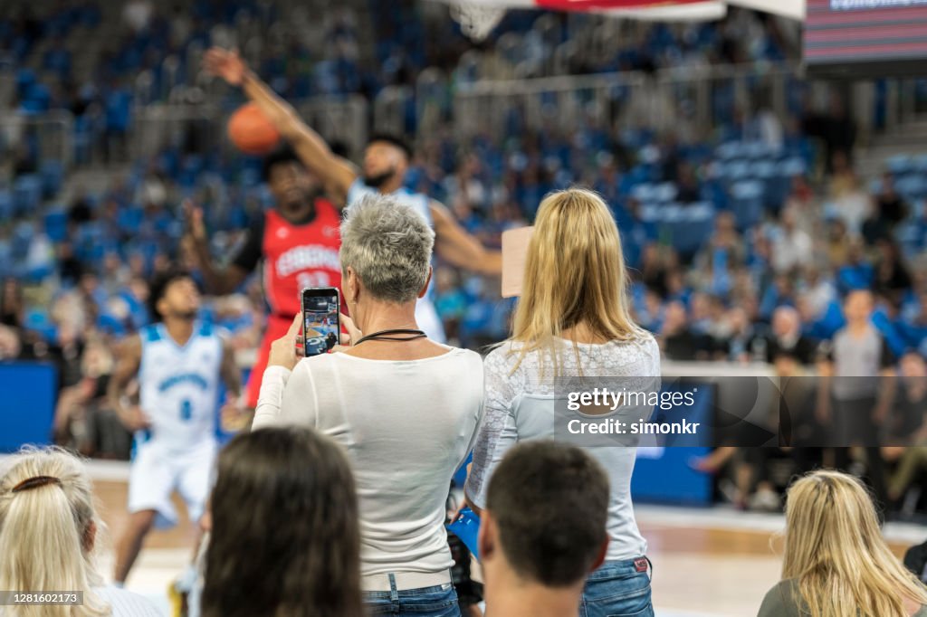 Spectators photographing during the match