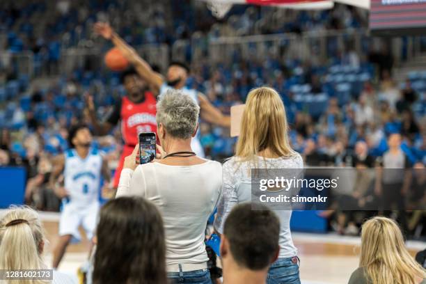 spectators photographing during the match - basketball all access stock pictures, royalty-free photos & images