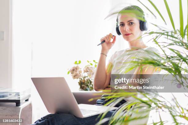 business frau im homeoffice mit laptop - blick in die kamera - frau in die kamera fotografías e imágenes de stock