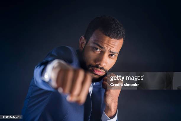 close-up of businessman in punch stance - fighting stance stock pictures, royalty-free photos & images