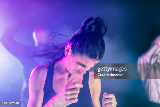 mujer bailando en club nocturno - cola alta de caballo fotografías e imágenes de stock