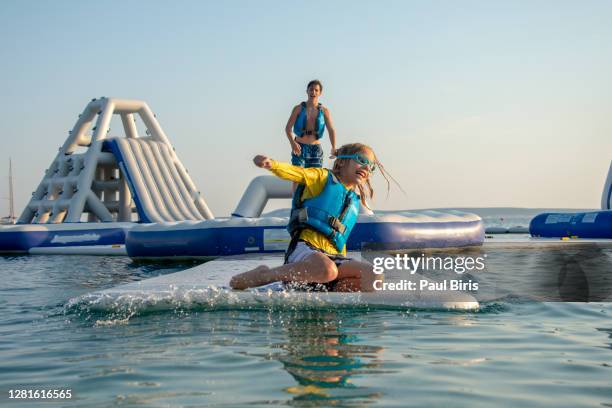 happy brothers playing on inflatable water slide, croatia - waterpark stock pictures, royalty-free photos & images