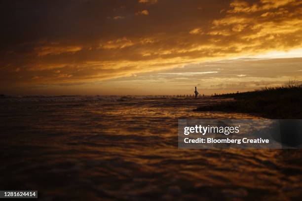waves crash onto the beack - beack sunset stock pictures, royalty-free photos & images