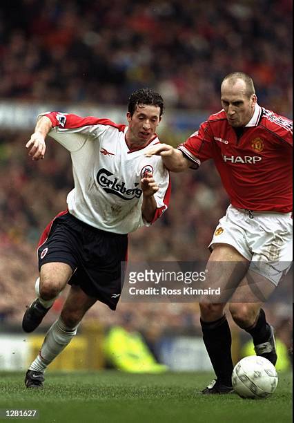 Robbie Fowler of Liverpool takes on Jaap Stam of Manchester United in the FA Cup fourth round clash at Old Trafford in Manchester, England. United...