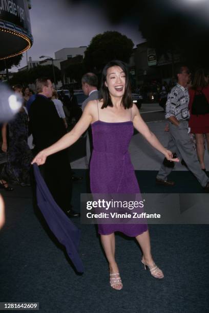 Macau-born actress Ming-Na Wen, wearing a purple dress with spaghetti straps, attends the premiere of 'Saving Private Ryan', held at the Mann Village...