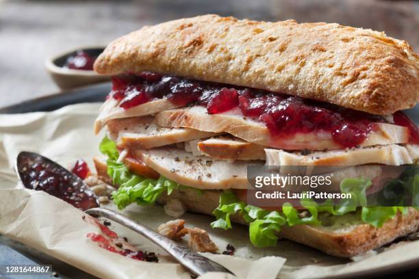 烤土耳其三明治與萊圖斯, 番茄和蔓越莓醬在恰巴塔邦。 - cranberry sauce 個照片及圖片檔