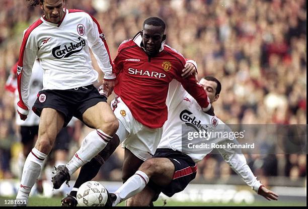 Dwight Yorke of Manchester United is taken out by Patrik Berger and Steve Harkness of Liverpool during the FA Cup fourth round clash at Old Trafford...