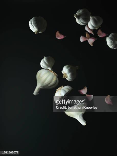 garlic falling on black background - flight food stock pictures, royalty-free photos & images