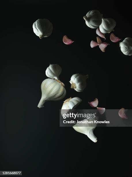 garlic falling on black background - garlic clove - fotografias e filmes do acervo