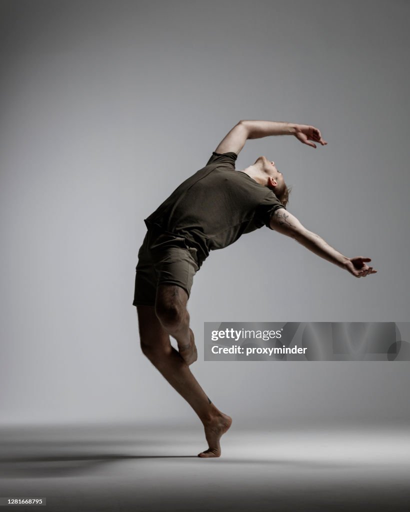 Bailarín masculino moderno sobre fondo gris