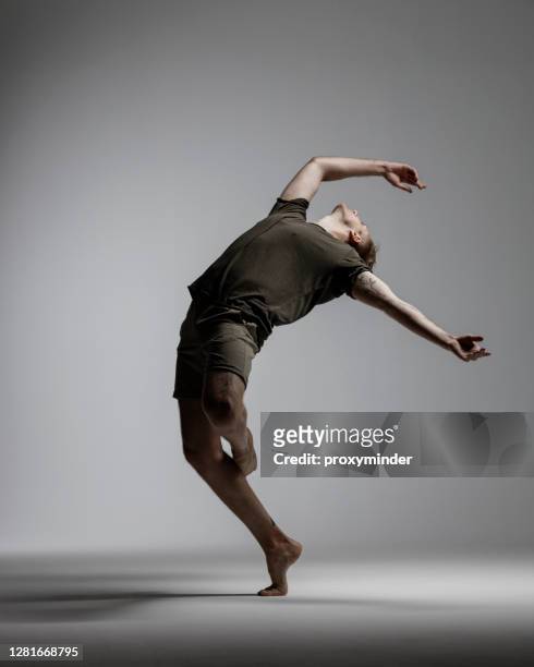 ballerino maschile moderno su sfondo grigio - tipo di danza foto e immagini stock