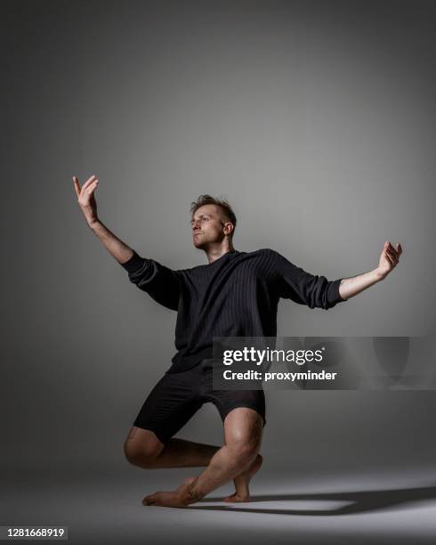 moderne männliche tänzerin auf grauem hintergrund - modern dance stock-fotos und bilder