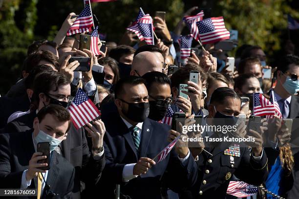 Guests cheer on President Donald Trump and First Lady Melania Trump as they walk to the South Lawn to depart the White House on October 22, 2020 in...