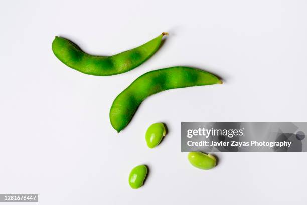 fresh soybeans edamame on white colored background - soybean stock-fotos und bilder