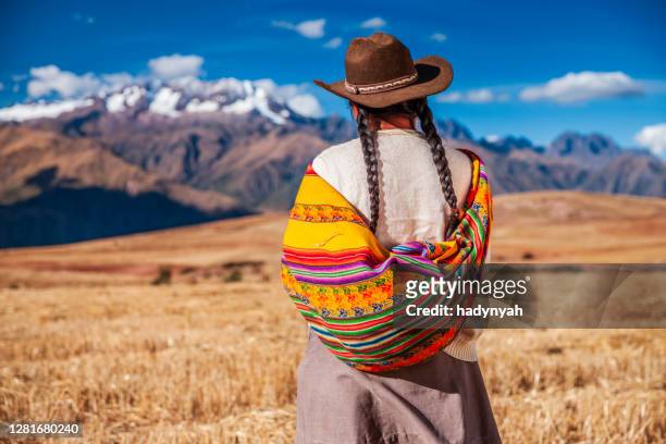 femme péruvienne dans l’habillement national regardant des andes, la vallée sacrée - femme perou photos et images de collection