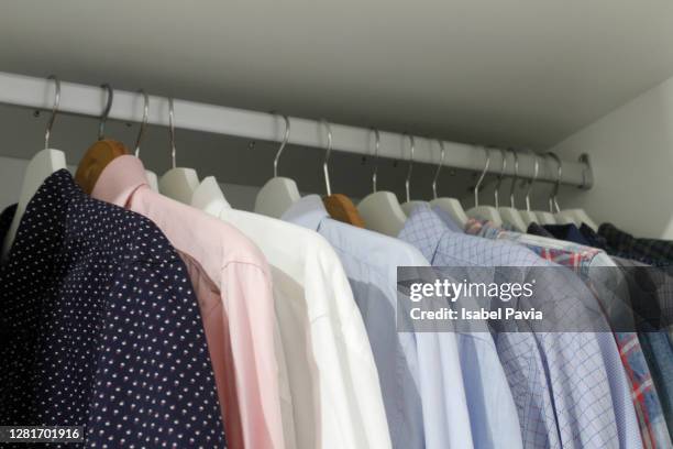 close-up of shirts hanging in row - clothes hanging on rack at store for sale foto e immagini stock