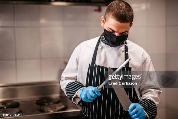chef-kok die mes verscherpt - tafelmes stockfoto's en -beelden