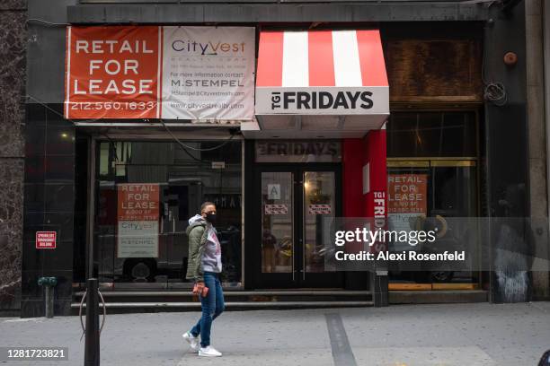 Person wearing a mask walks past a For Lease sign at a closed down TGI Fridays in the Financial District on October 22, 2020 in New York City. The...