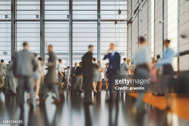 large group of business people in convention centre - crowd of people walking stock pictures, royalty-free photos & images