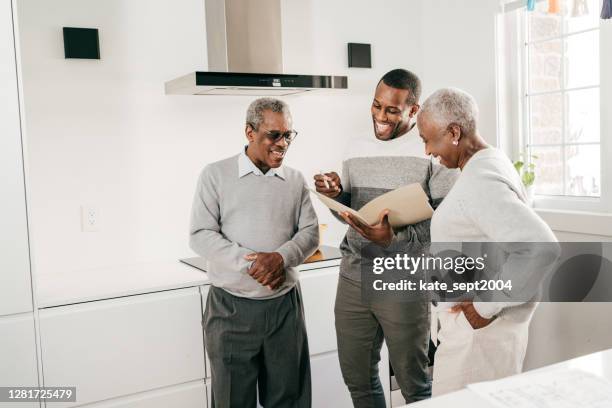 insurance broker and seniors in the kitchen - baby boomer generation stock pictures, royalty-free photos & images