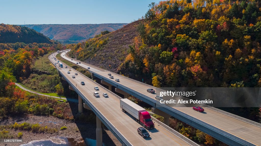Malerische Luftaufnahme der hoch gelegenen Brücke am Pennsylvania Turnpike, die an einem sonnigen Tag im Herbst zwischen den Bergen in Appalachian liegt.