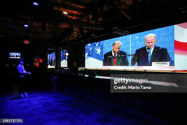 An employee watches a broadcast of the final debate between President Donald Trump and Democratic presidential nominee Joe Biden in the shuttered...