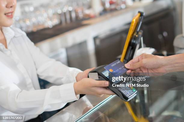 customer using dummy credit card for purchase to waitress without touching edc at cashier in cafe restaurant to keep distancing during covid pandemic. cashless, technology, wireless payment concept. - electronic data capture stock pictures, royalty-free photos & images
