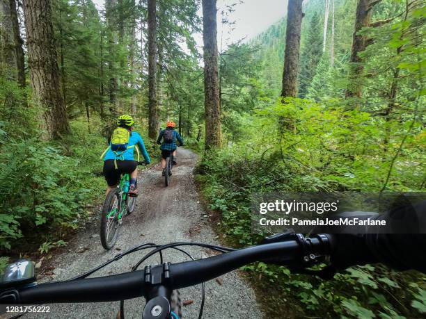 pov, famille de vélo de montagne équitation sur le sentier de forêt - chemin de terre photos et images de collection