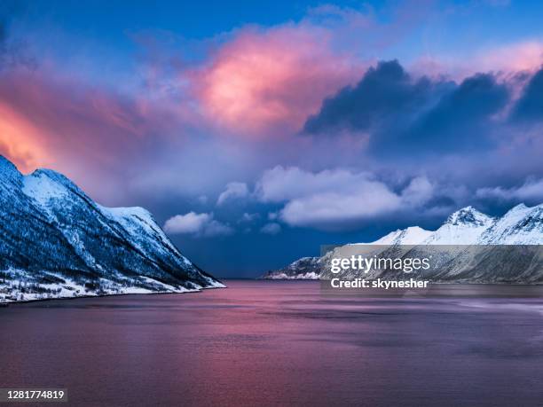 ersjordbotn view with dramatic cloudscape above snowcapped mountain range in senja, norway. - norway landscape stock pictures, royalty-free photos & images