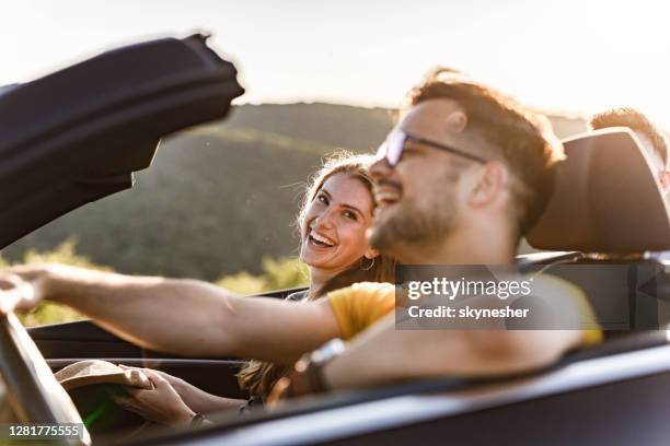 happy couple enjoying in road trip by convertible car. - convertible stock pictures, royalty-free photos & images