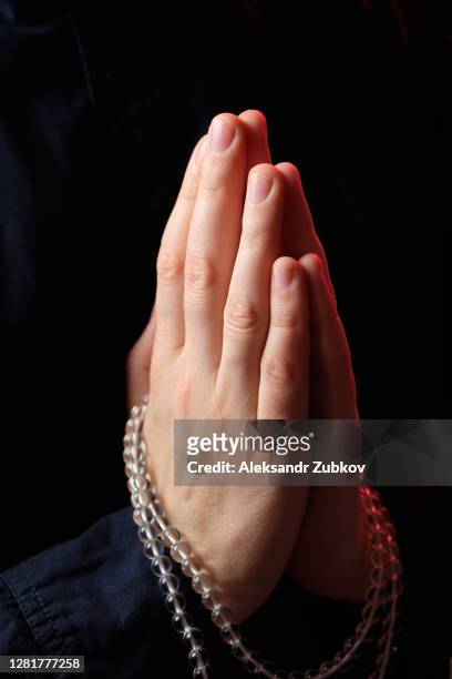 transparent crystal prayer beads in the hands of a young man, he is doing yoga. the guy's hands are folded in a prayer gesture namaste. religious symbol of the concept of faith, prayer, meditation and mantra repetition. - namaste bildbanksfoton och bilder